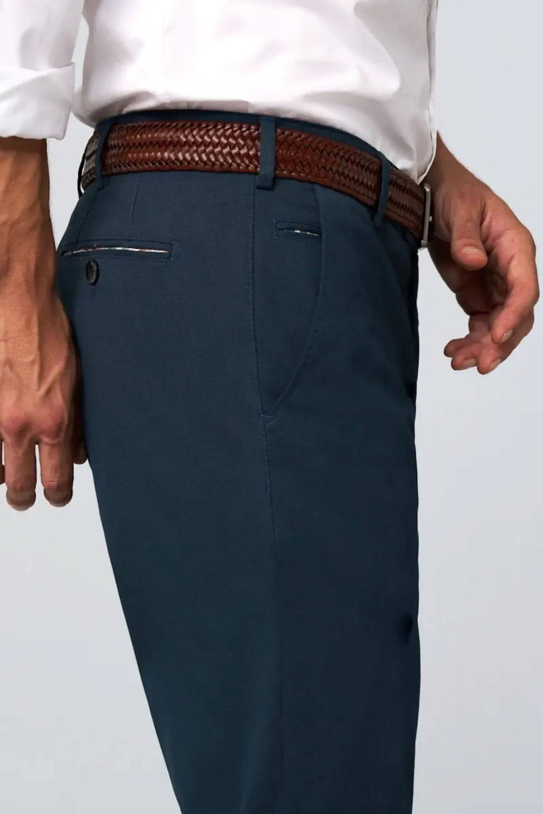 Ceinture tressée en cuir marron portée avec un pantalon bleu, idéale pour un look décontracté ou habillé.