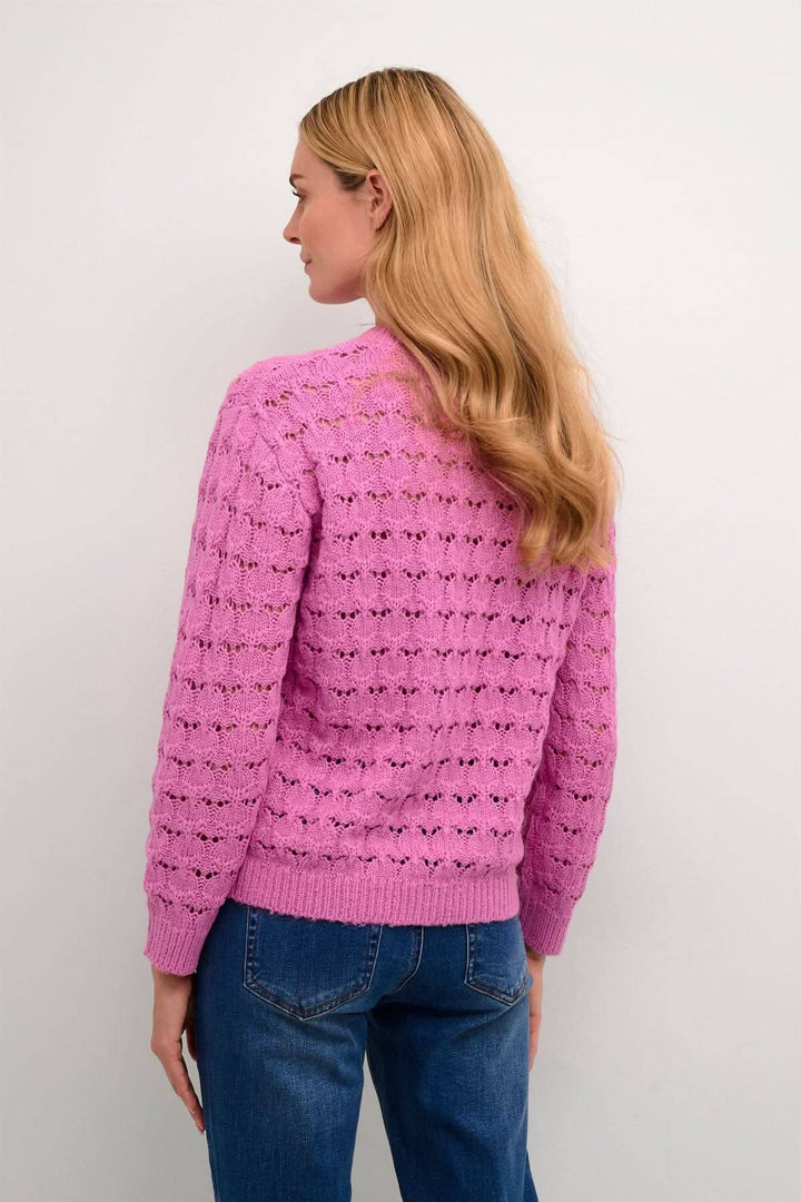 Chandail Elena rose avec manches longues et détails de coutures transparents, porté avec un jean.