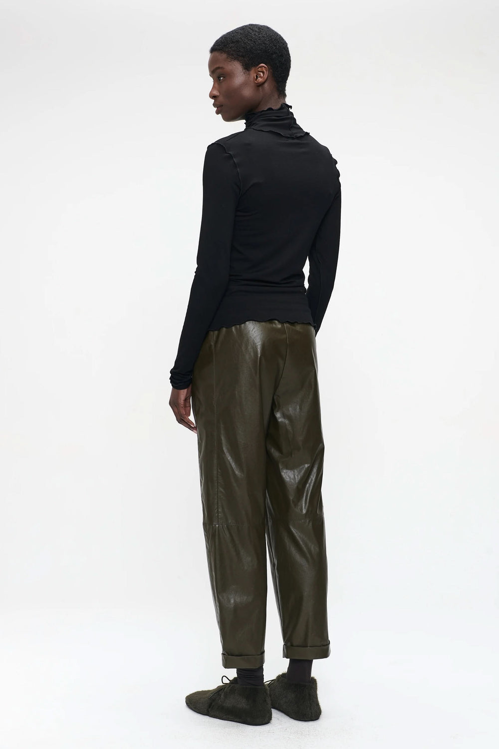 Chandail Janice à col roulé ajusté, porté avec un pantalon élégant, offrant un look moderne et minimaliste.