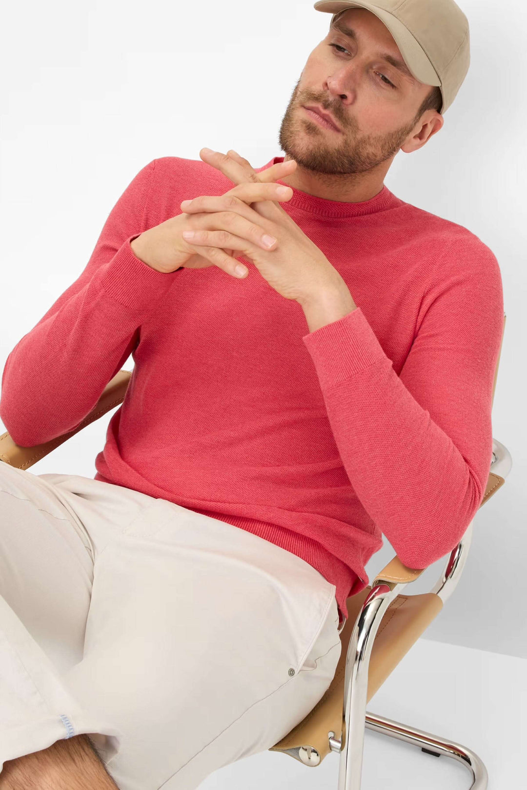 Chandail Rick col rond rose sur un homme assis, style sobre et élégant, parfait pour la mi-saison.