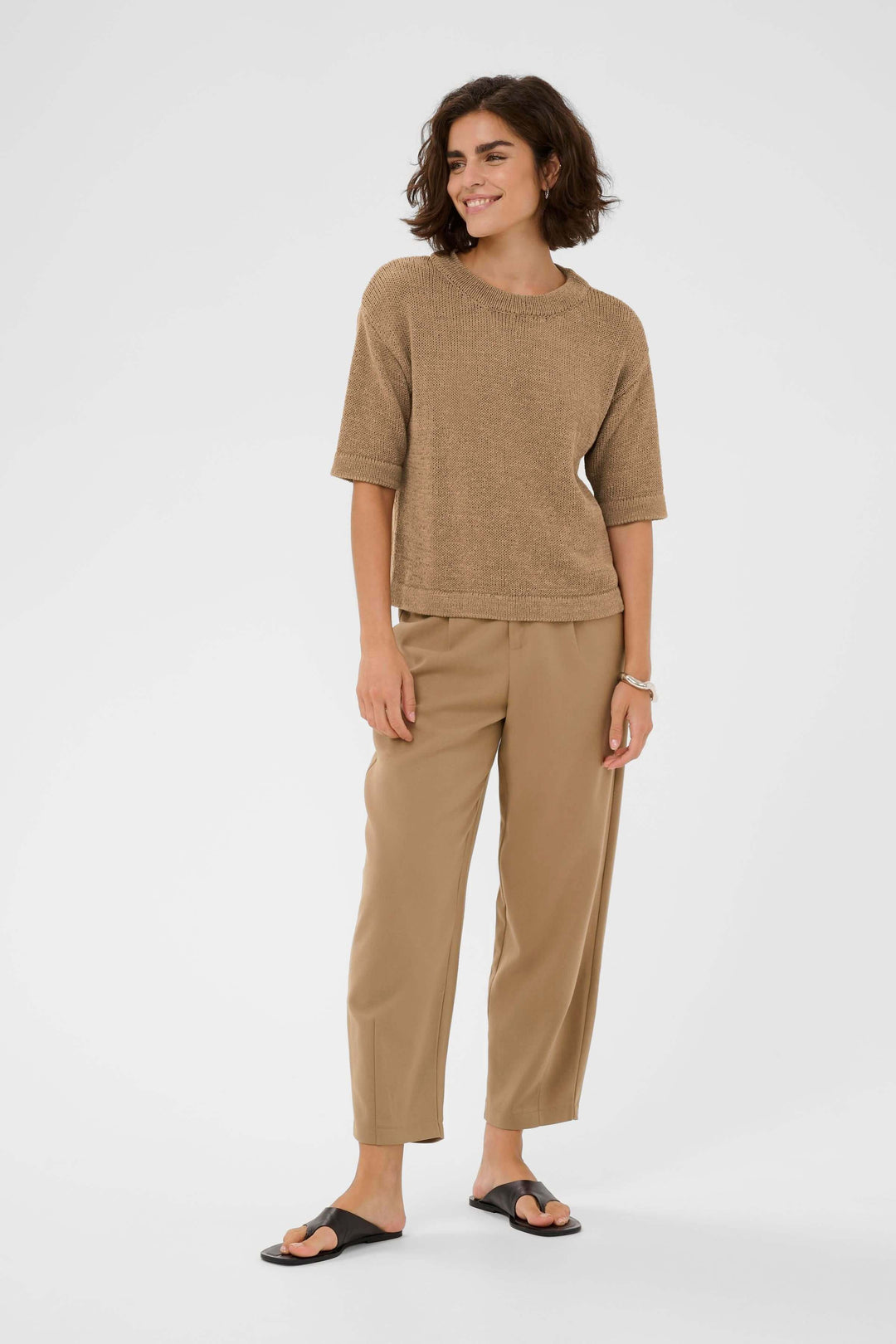 Femme portant le Chandail Sevita en maille légère avec des manches courtes et une coupe droite pour un look décontracté et moderne.