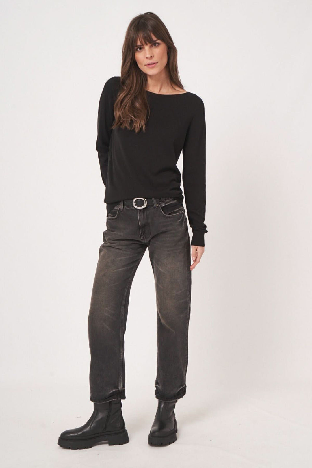 Chandail basique à encolure bateau, porté avec un jean noir pour un look décontracté et élégant.