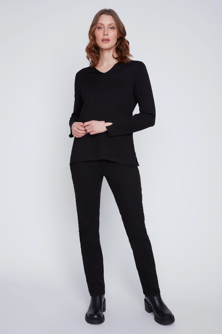 Femme portant un Chandail col V noir à manches longues avec un pantalon ajusté, illustrant un look chic et minimaliste.