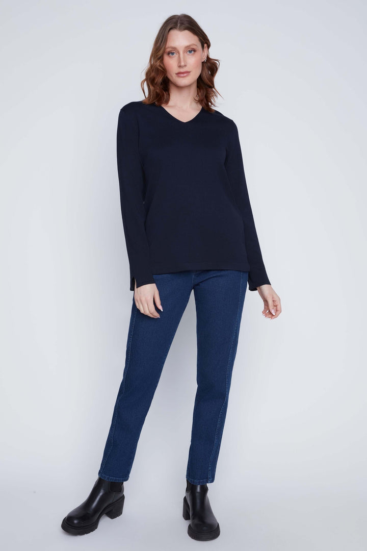 Femme portant un chandail col V à manches longues, coupe fluide et élégante, idéal pour tenues chic et minimalistes.