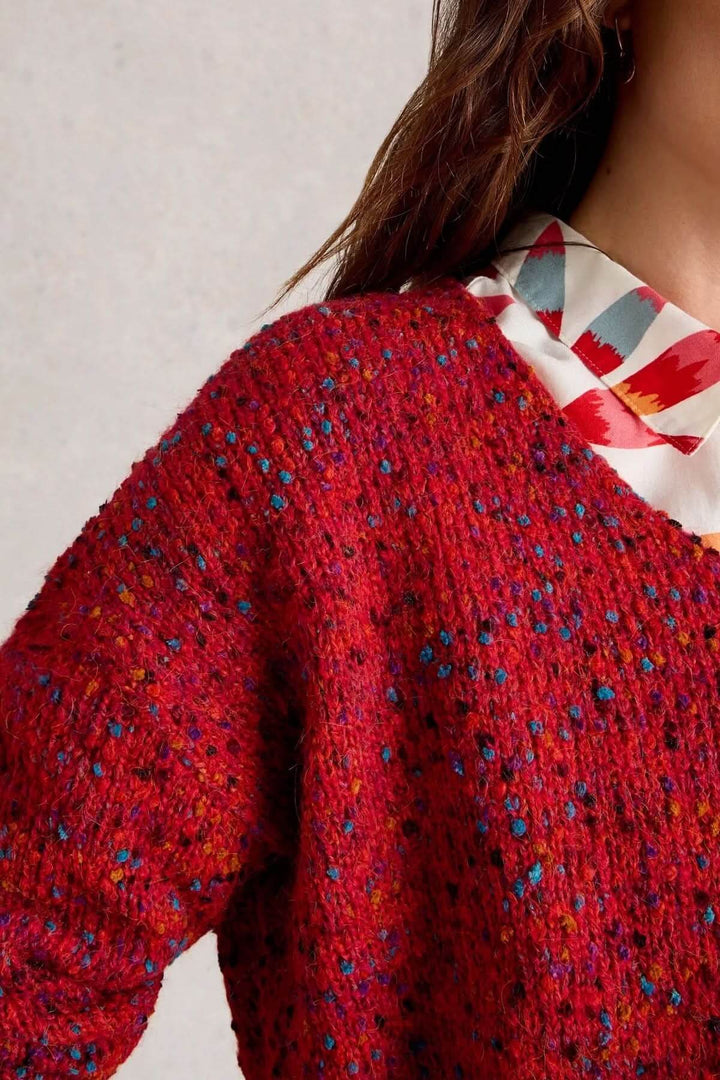 Chandail col en V rouge chiné avec texture moderne et confortable, porté sur chemise à motifs pour un style décontracté et tendance.