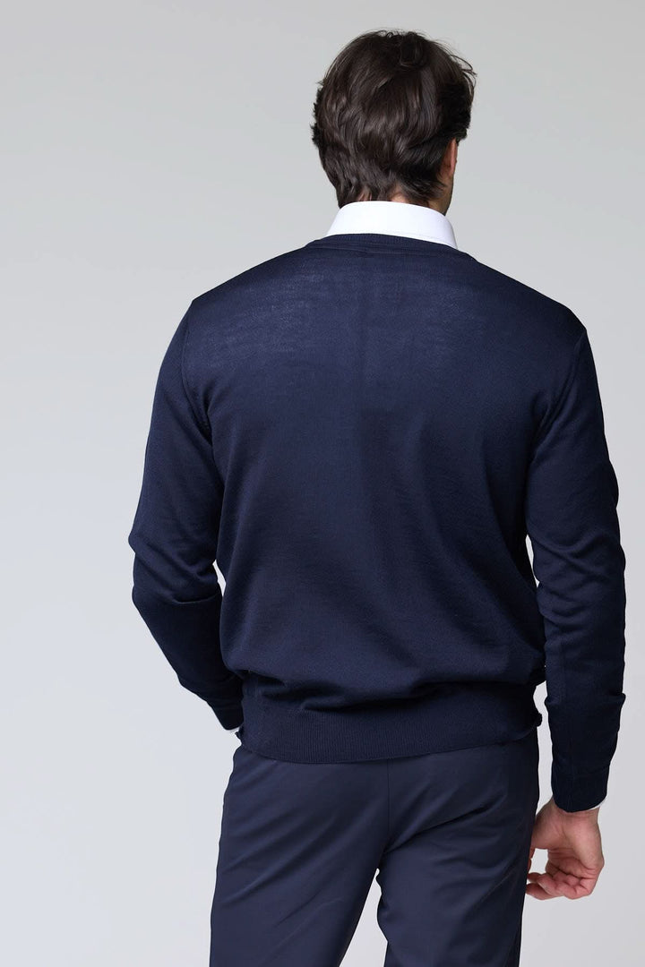 Homme portant un chandail col en V en laine mérinos bleu marine, style élégant et intemporel, vue arrière.