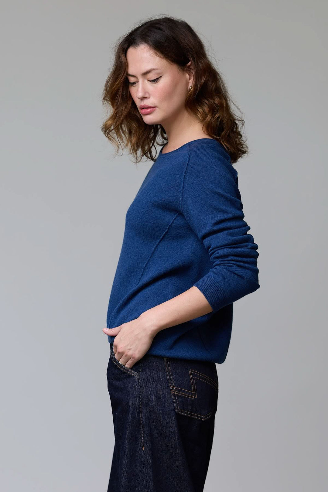 Femme portant un chandail à col rond bleu, coupe classique, maille fine, chaleur et élégance pour un style épuré ou habillé.