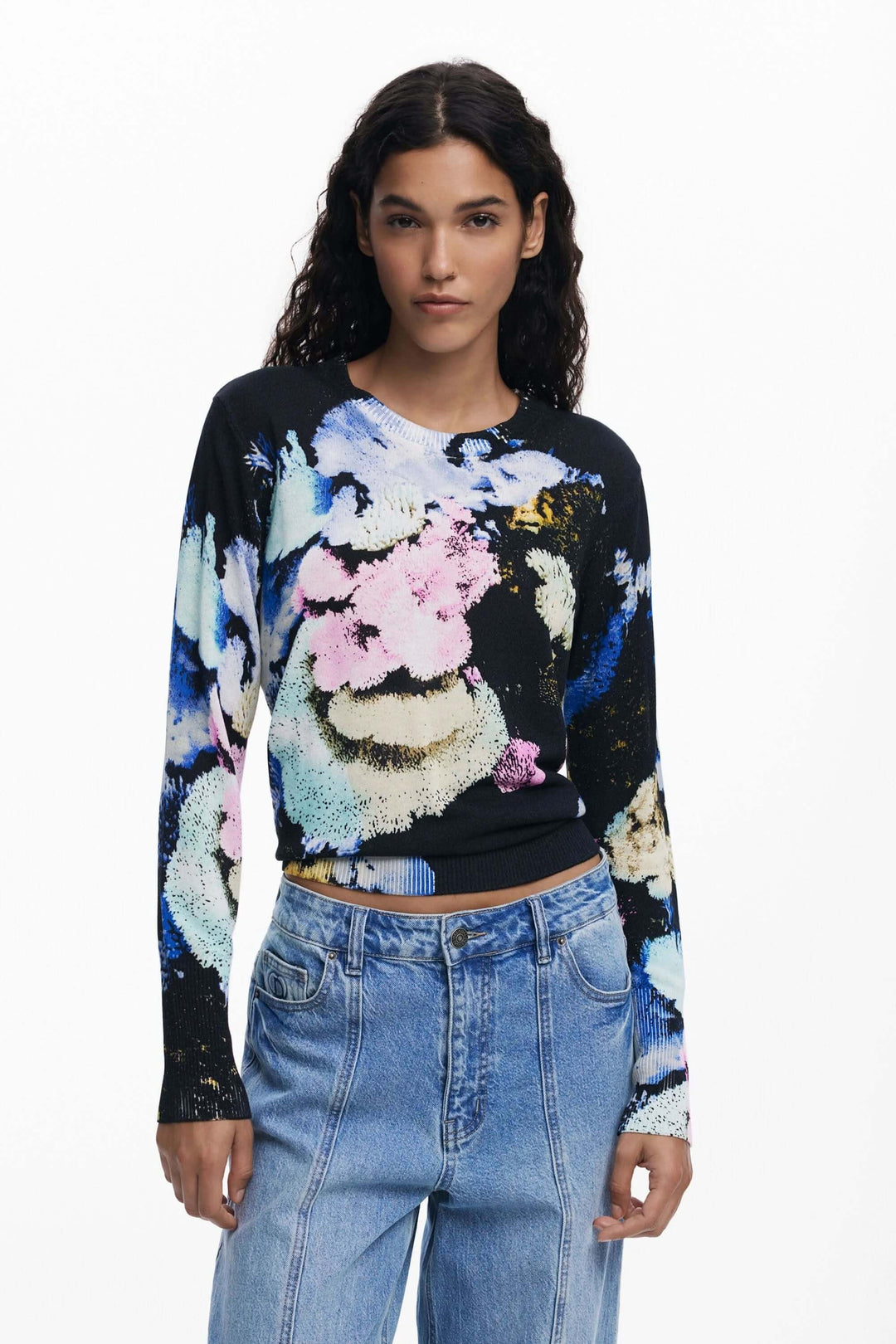 Chandail à col rond imprimé floral abstrait, coupe près du corps, porté avec un pantalon taille haute, mode féminine élégante.