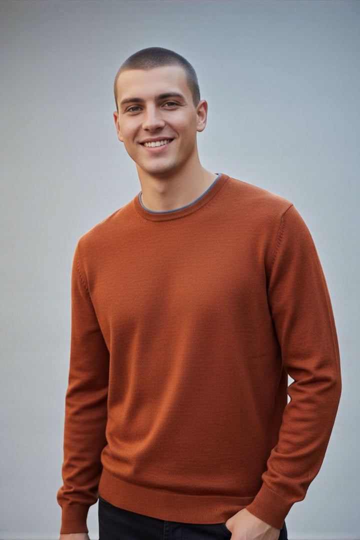 Homme portant un chandail col rond en laine mérinos avec coudes contrastants, design élégant et maille fine, idéal pour un style décontracté chic.