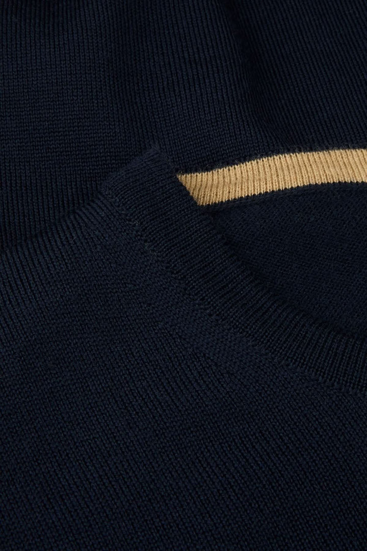 Chandail col rond en laine mérinos avec coudes contrastants bleu foncé, détail de la texture fine et coudière intégrée.