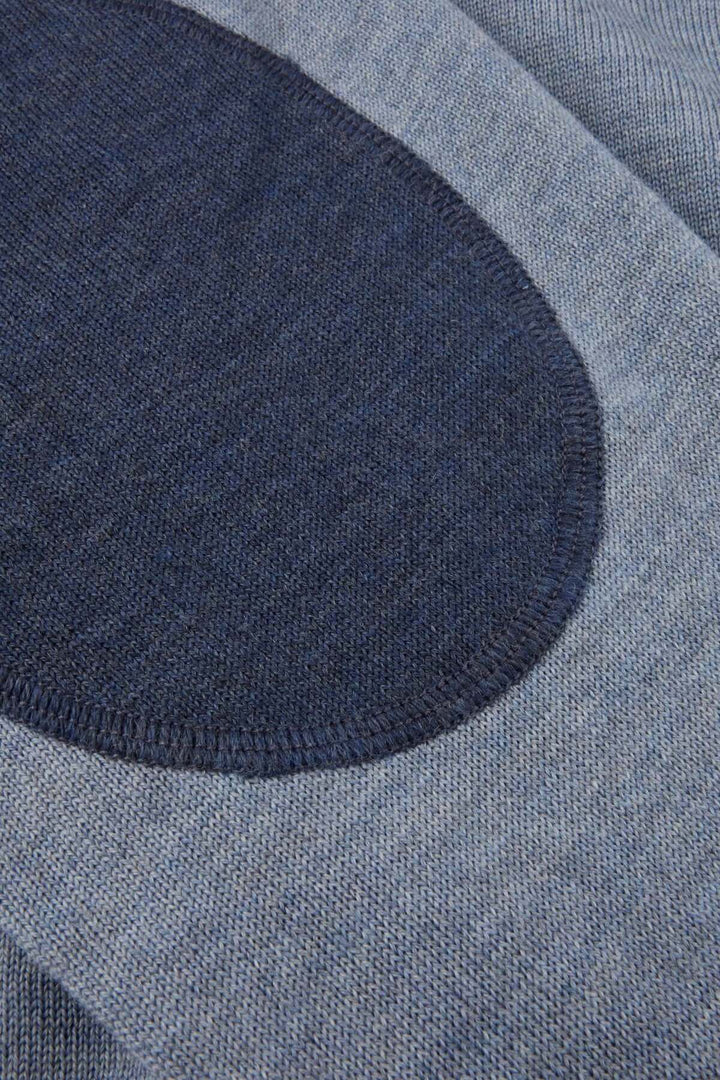 Chandail col rond en laine mérinos avec coudes contrastants, featuring close-up of dark blue elbow patch on light knitted fabric.