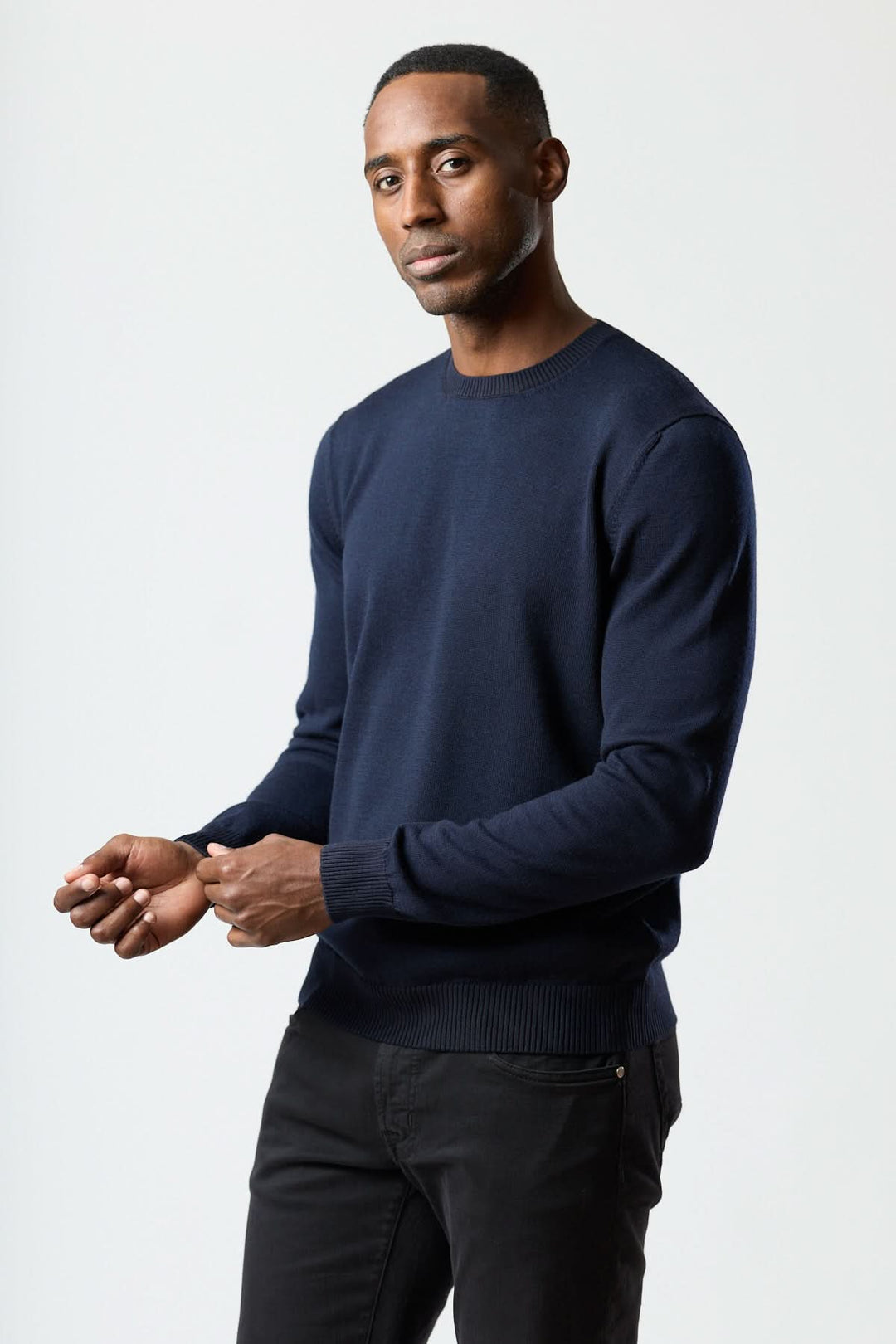 Homme portant un chandail col rond essentiel bleu marine, avec finitions côtelées pour un style moderne et confortable.