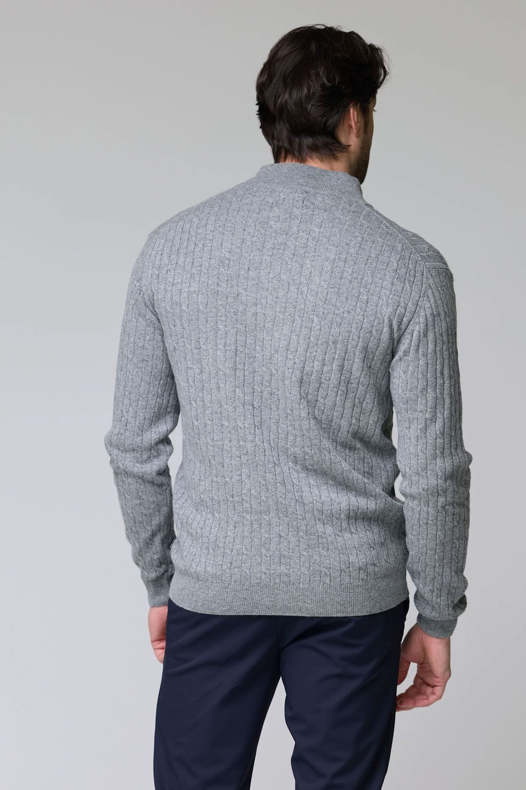 Dos d'un homme portant un chandail à demi-glissière torsadé en laine gris, parfait pour un style élégant et décontracté.