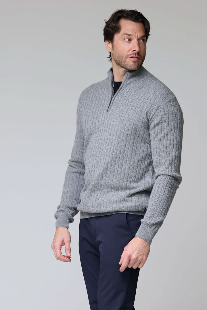 Homme portant un chandail à demi-glissière torsadé en laine gris avec col montant, manches longues, et poignets côtelés.