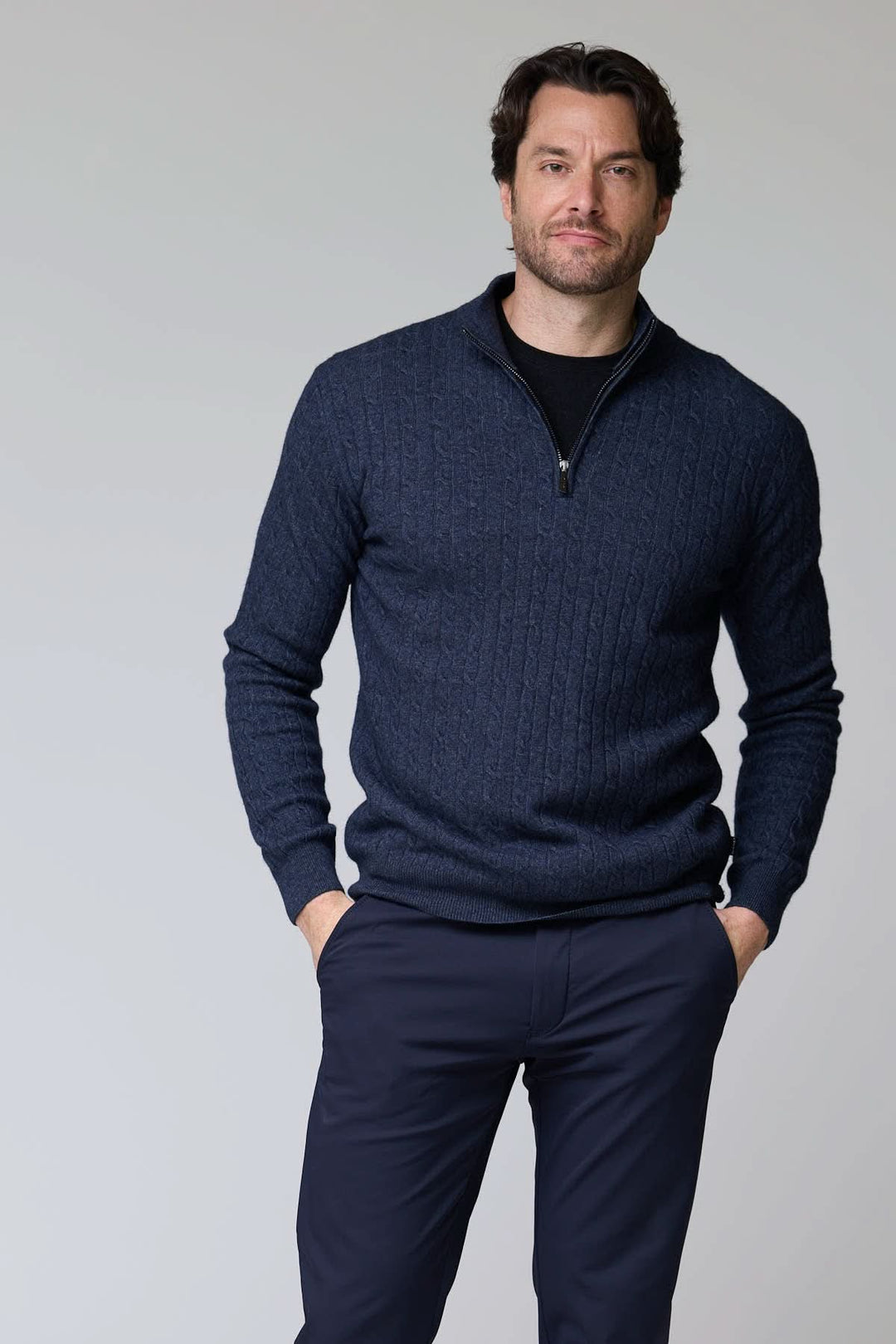 Chandail à demi-glissière torsadé en laine, tricot torsadé bleu marine, col montant, homme debout, mains dans les poches.