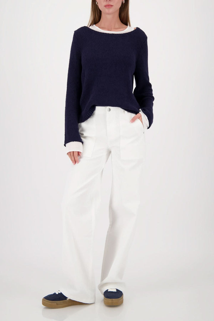 Femme portant un chandail à effet superposé col rond avec finition contrastante, look moderne et polyvalent.