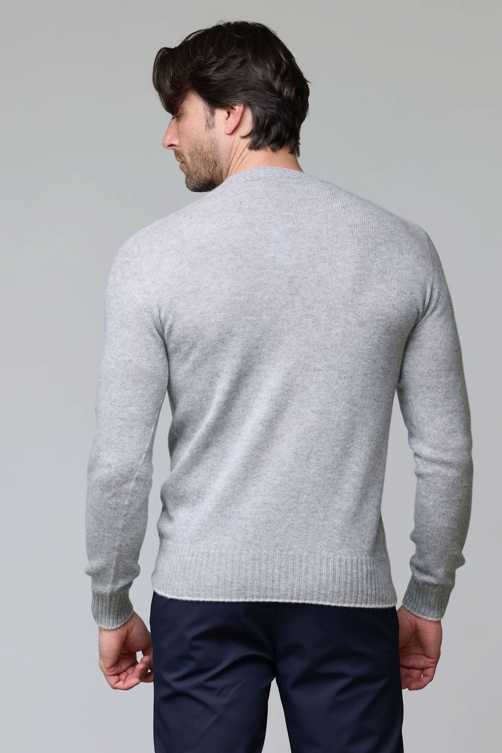Dos d'un homme portant un chandail en laine gris avec manches longues et finition côtelée, coupe ajustée et élégante.