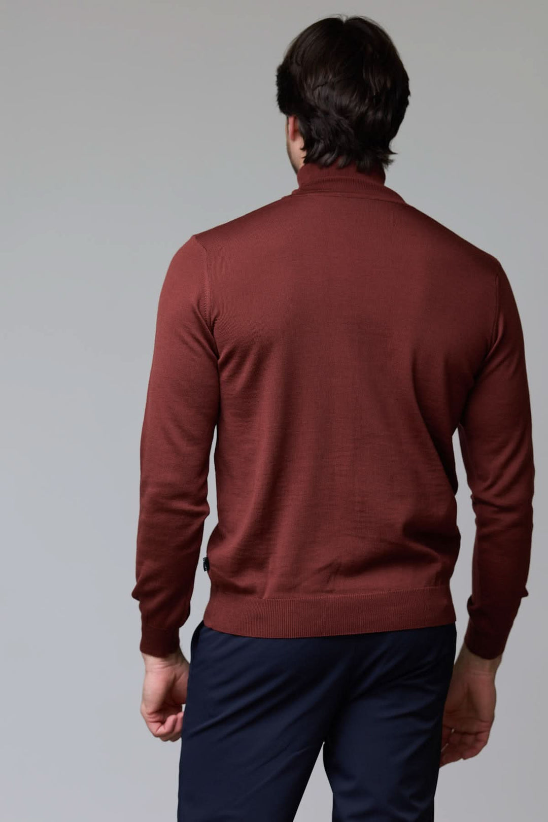 Chandail en laine mérinos fine pour homme de dos, couleur marron, design élégant avec col rond tricoté et coupe droite ajustée.