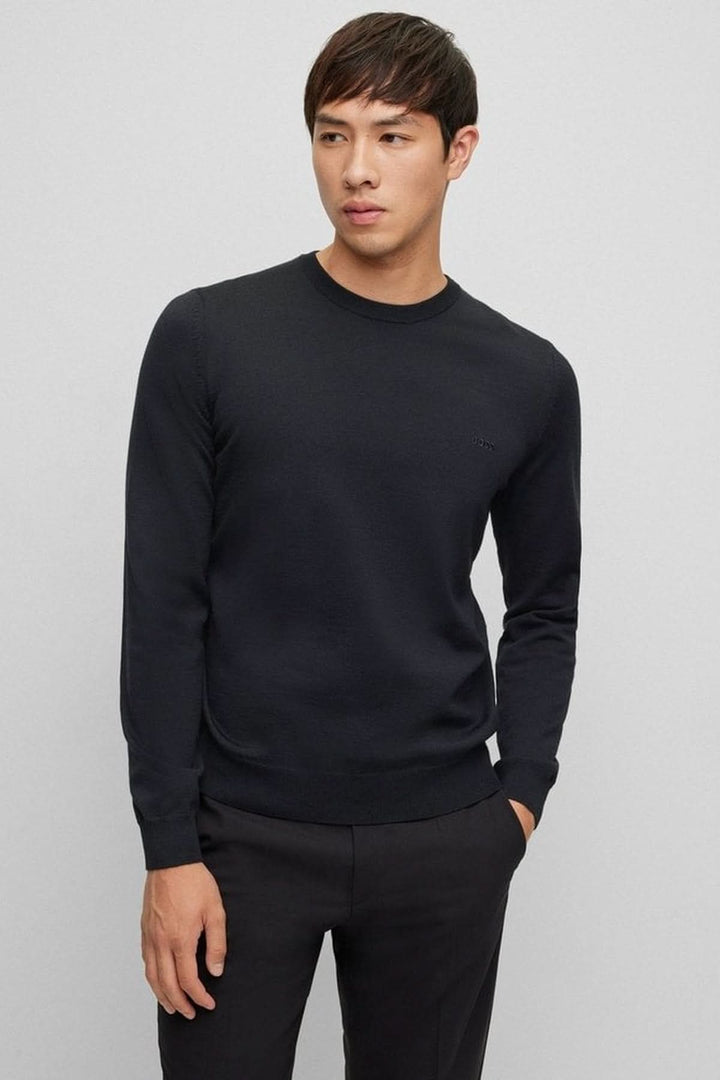Homme portant un chandail en laine vierge Botto noir de coupe régulière avec col rond pour un style élégant et moderne.