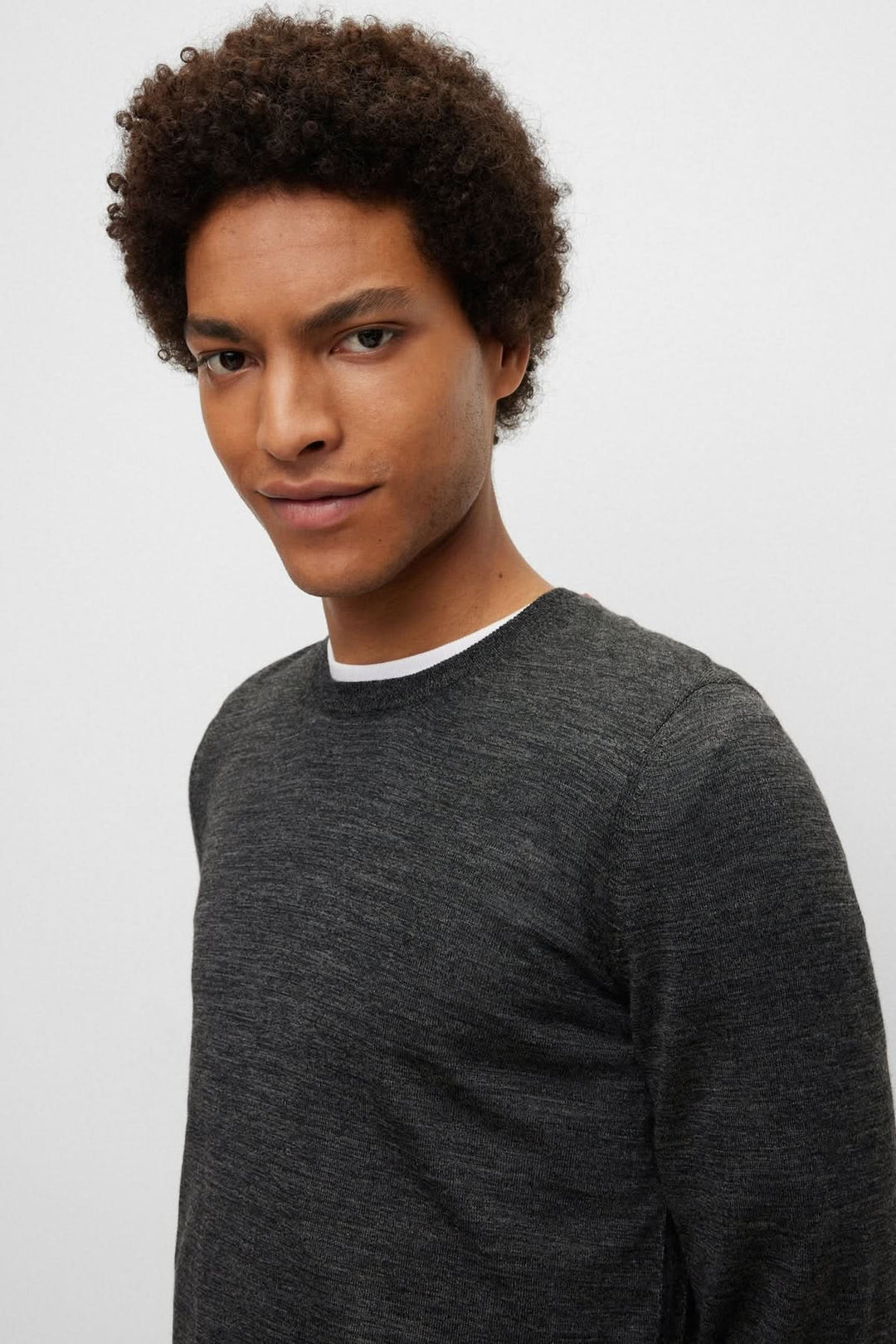 Homme portant un Chandail en laine vierge Leno gris avec encolure ronde classique et coupe ajustée.