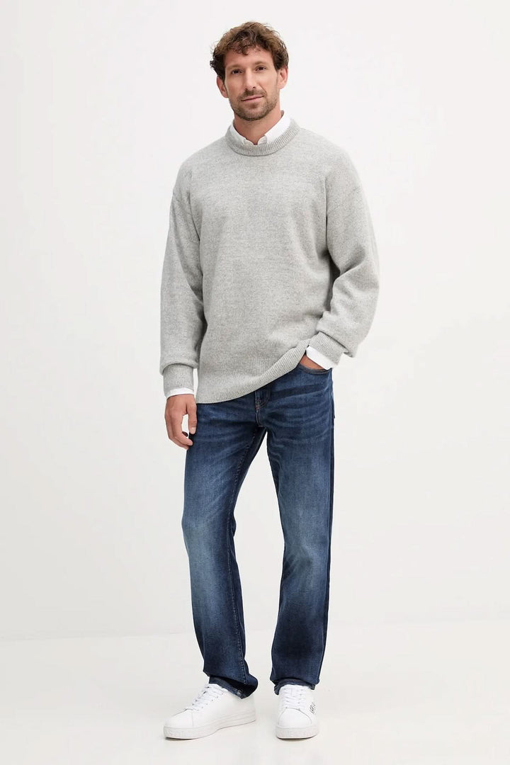 Homme portant un chandail en laine vierge coupe "oversize" gris avec finitions côtelées, de la marque BOSS.