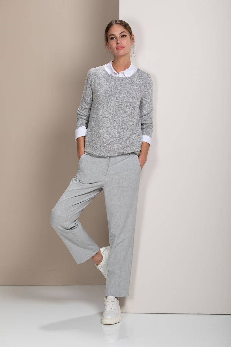 Femme portant un chandail en maille douce avec pantalon gris, look casual et moderne