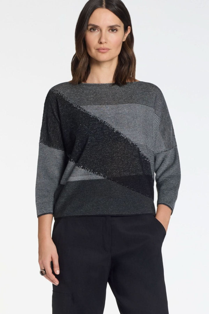 Femme portant un chandail en maille graphique manches 3/4, coupe fluide avec motif contrasté, idéal pour un style moderne et sophistiqué.