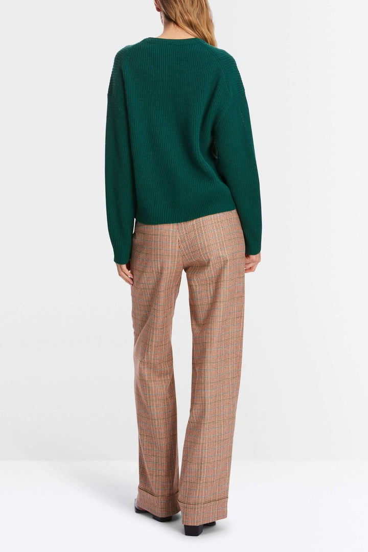 Pull en maille vert avec pantalon à carreaux, vue arrière, style décontracté et moderne.