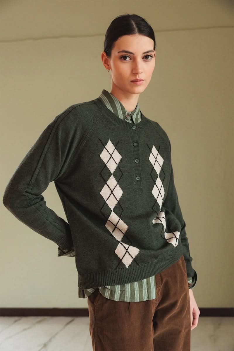 Femme portant un chandail en mérinos à motif losanges argyle avec col rond côtelé et patte de boutonnage partielle sur chemise rayée.