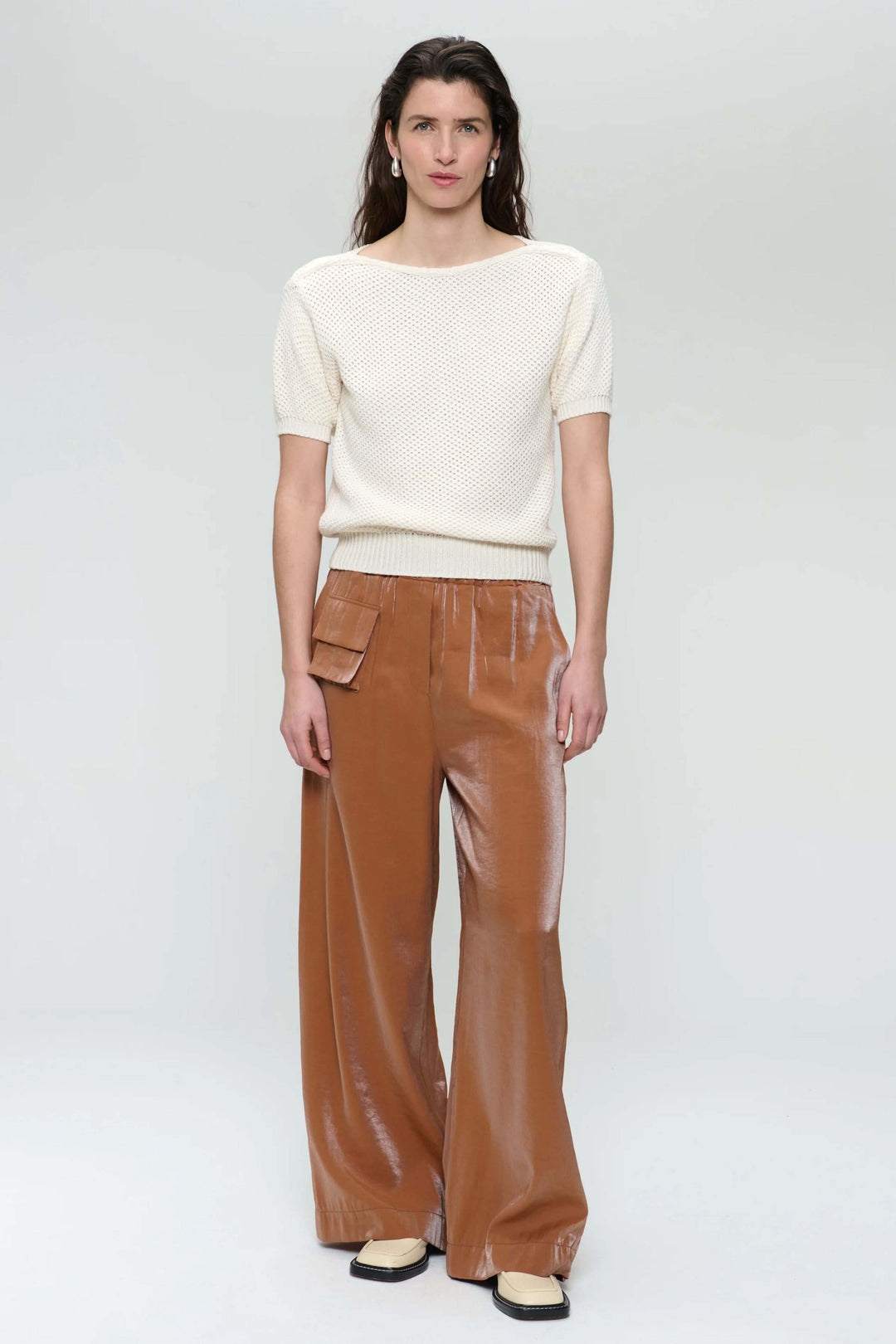 Chandail en tricot ajouré avec un pantalon large en cuir, look estival décontracté et élégant.