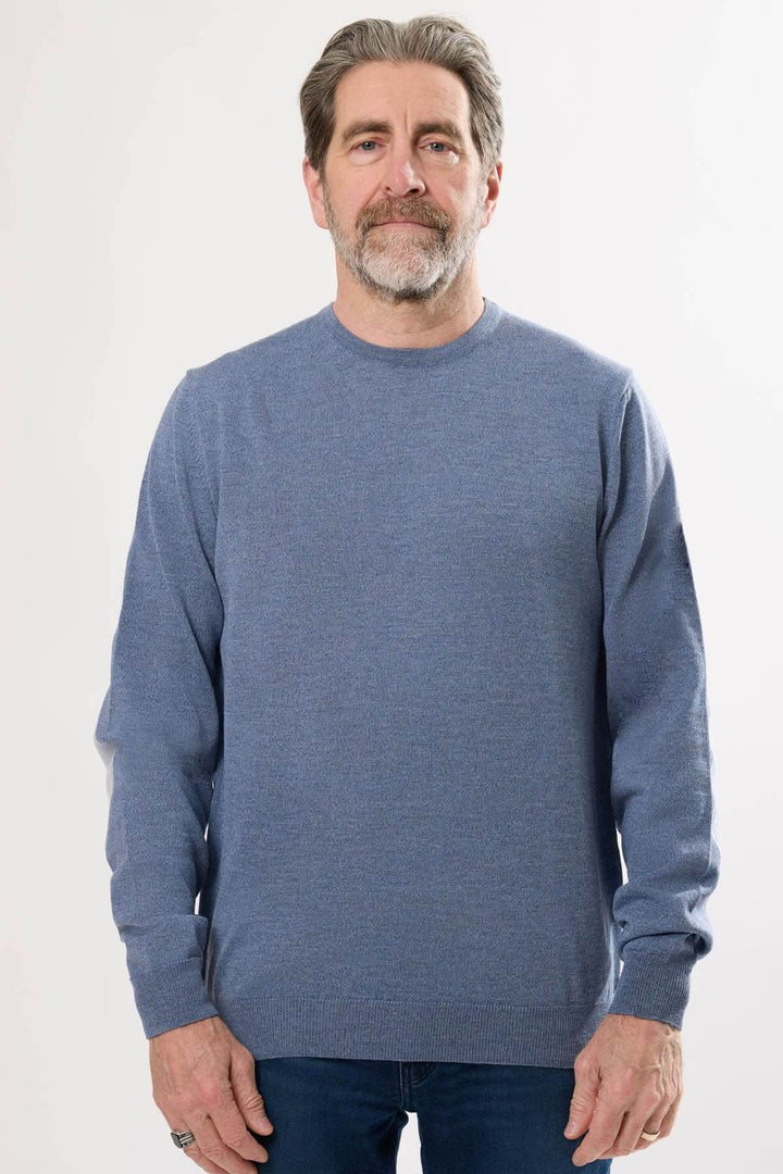 Homme portant un chandail bleu en tricot classique, col rond et manches longues, idéal pour les journées fraîches.