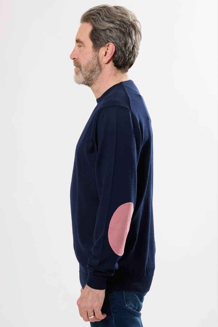 Chandail en tricot classique bleu marine avec coudières contrastantes ovales en rose, idéal pour les jours frais.