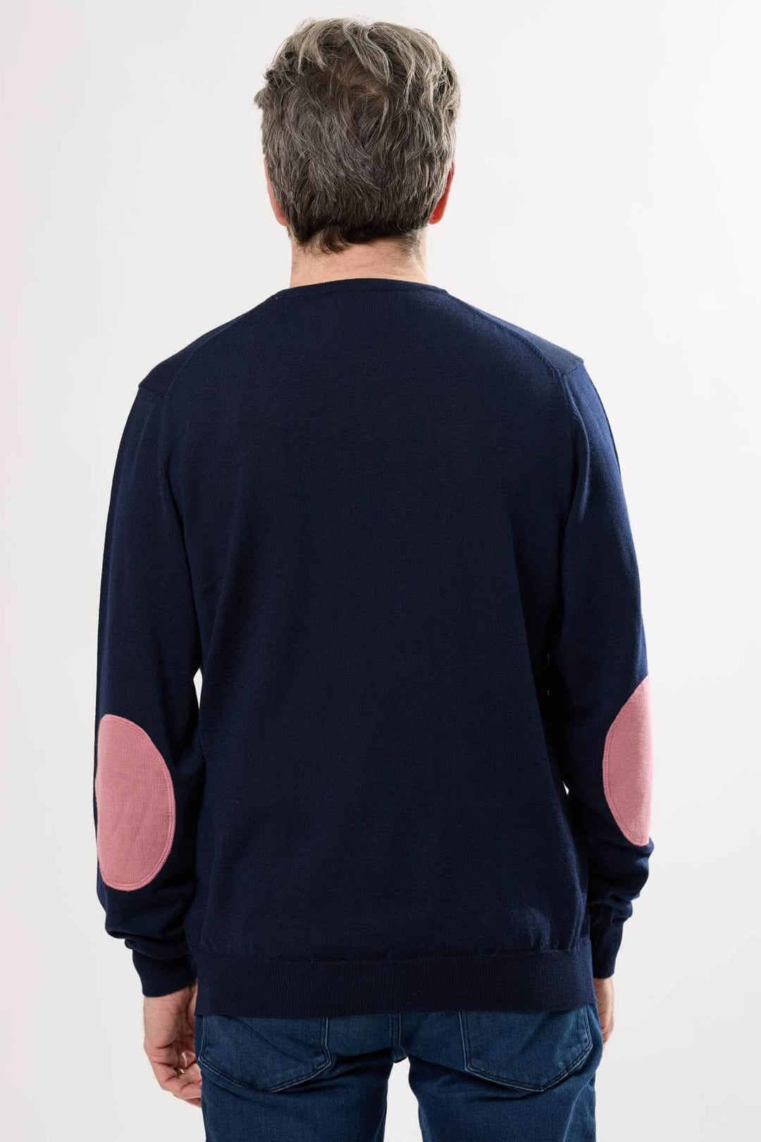 Chandail en tricot classique, dos avec coudières ovales contrastantes en rose sur fond bleu.