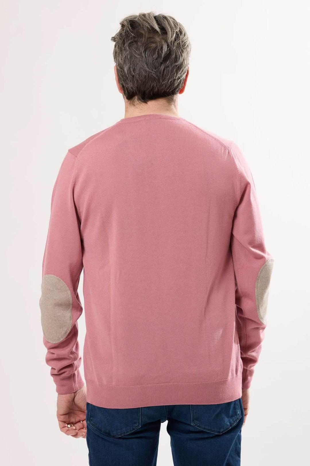 Homme vue de dos portant un chandail en tricot rose avec coudières contrastantes ovales.