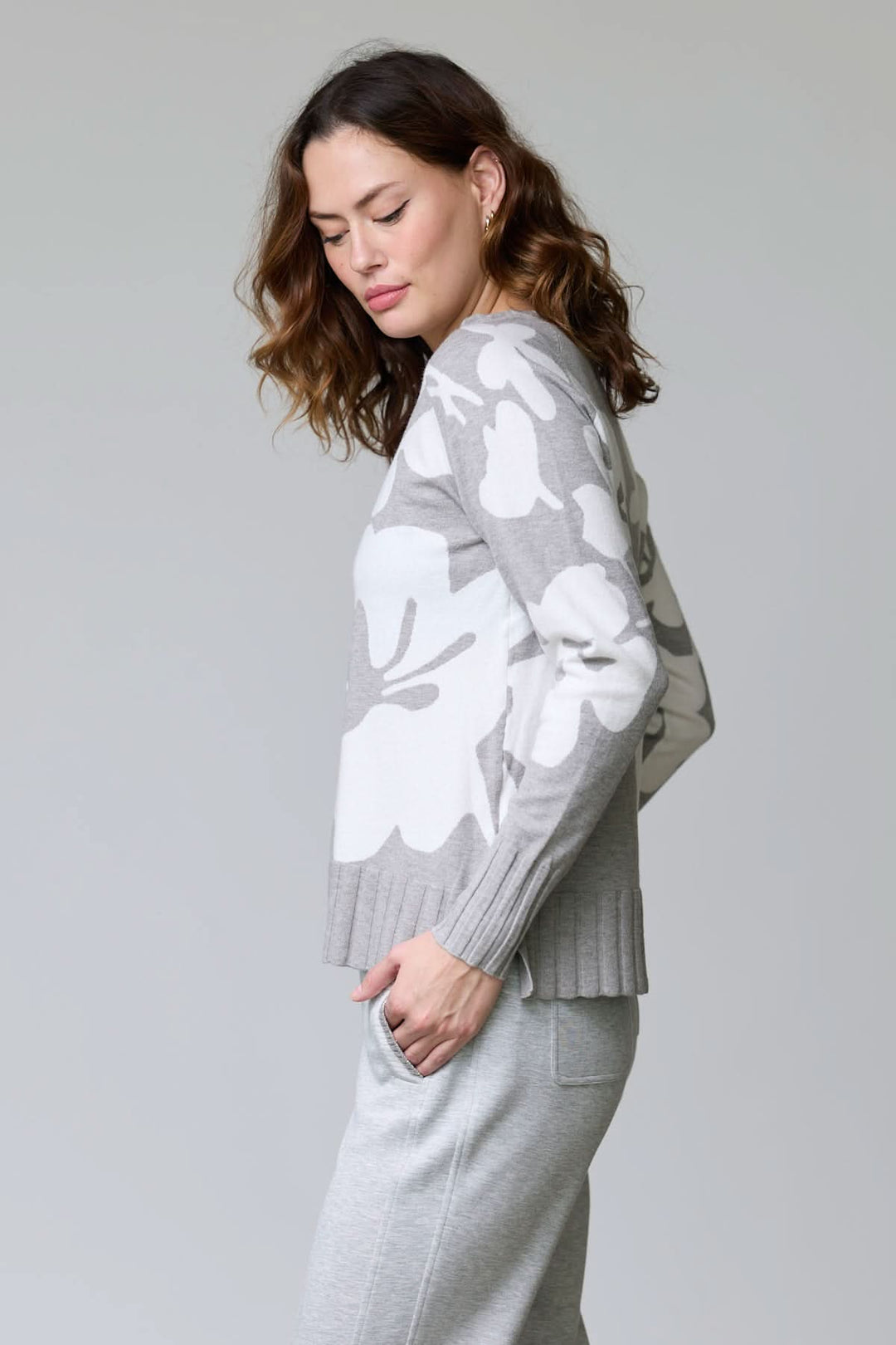 Femme portant un chandail en tricot à motif floral avec encolure ronde et maille souple, idéale pour la mode mi-saison.