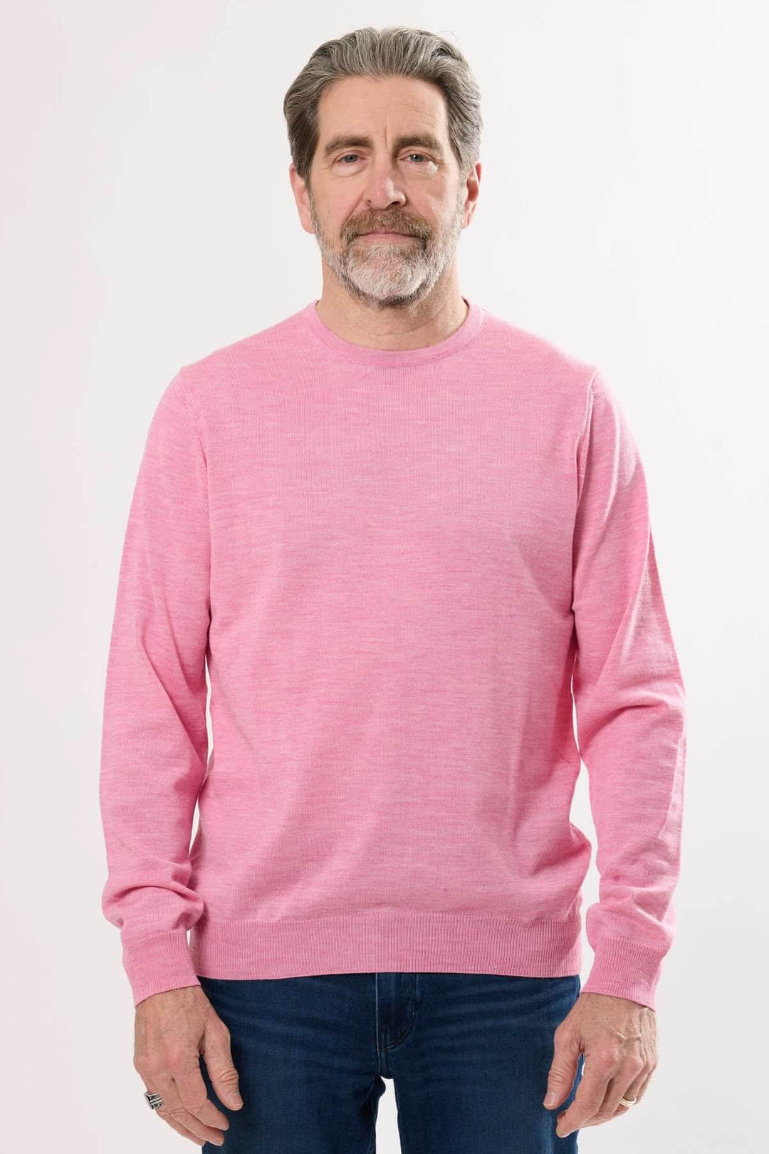 Homme portant un chandail léger rose à col rond, style décontracté, parfait pour la mi-saison.