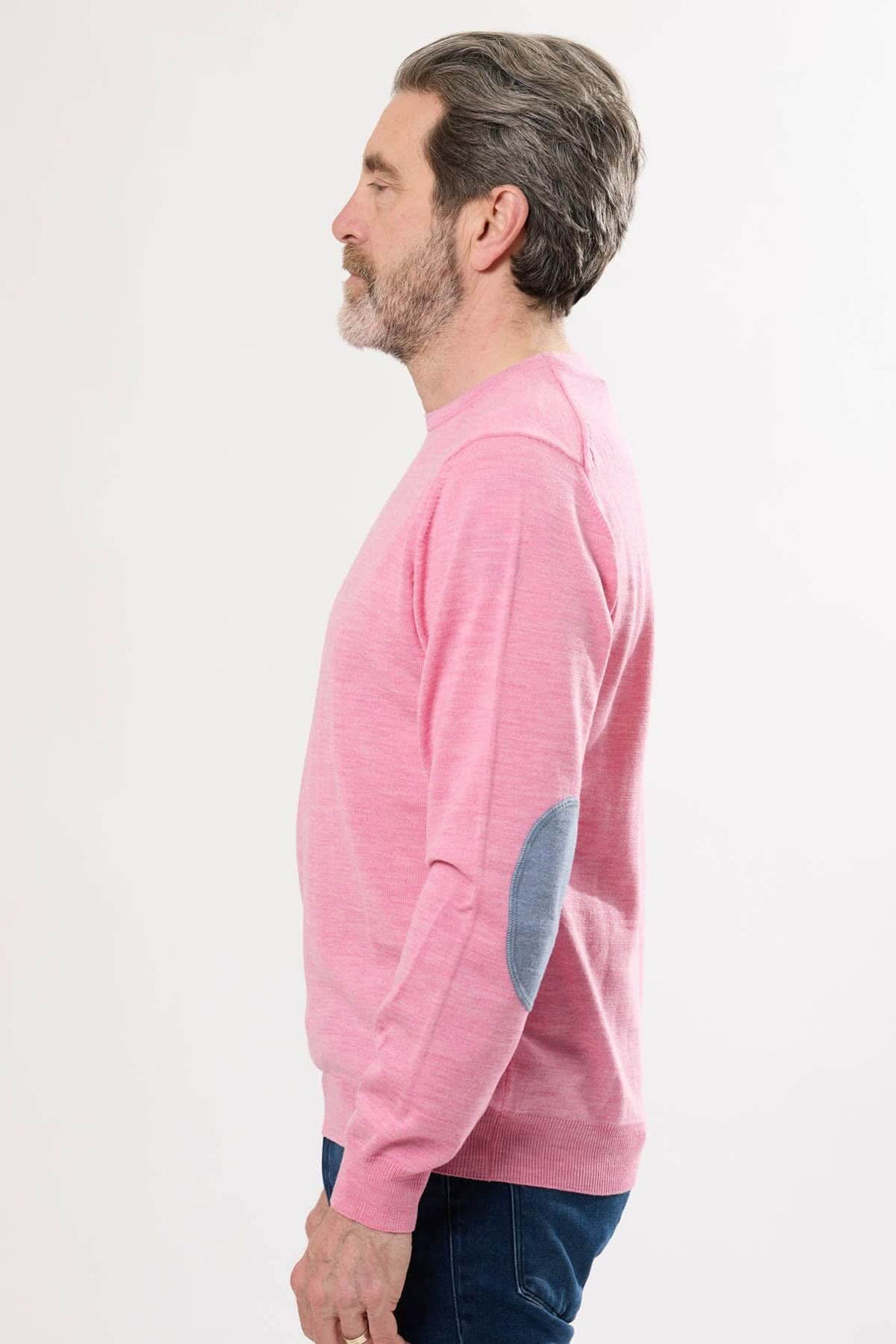 Homme portant un chandail léger rose à col rond avec coudières en tissu contrasté.