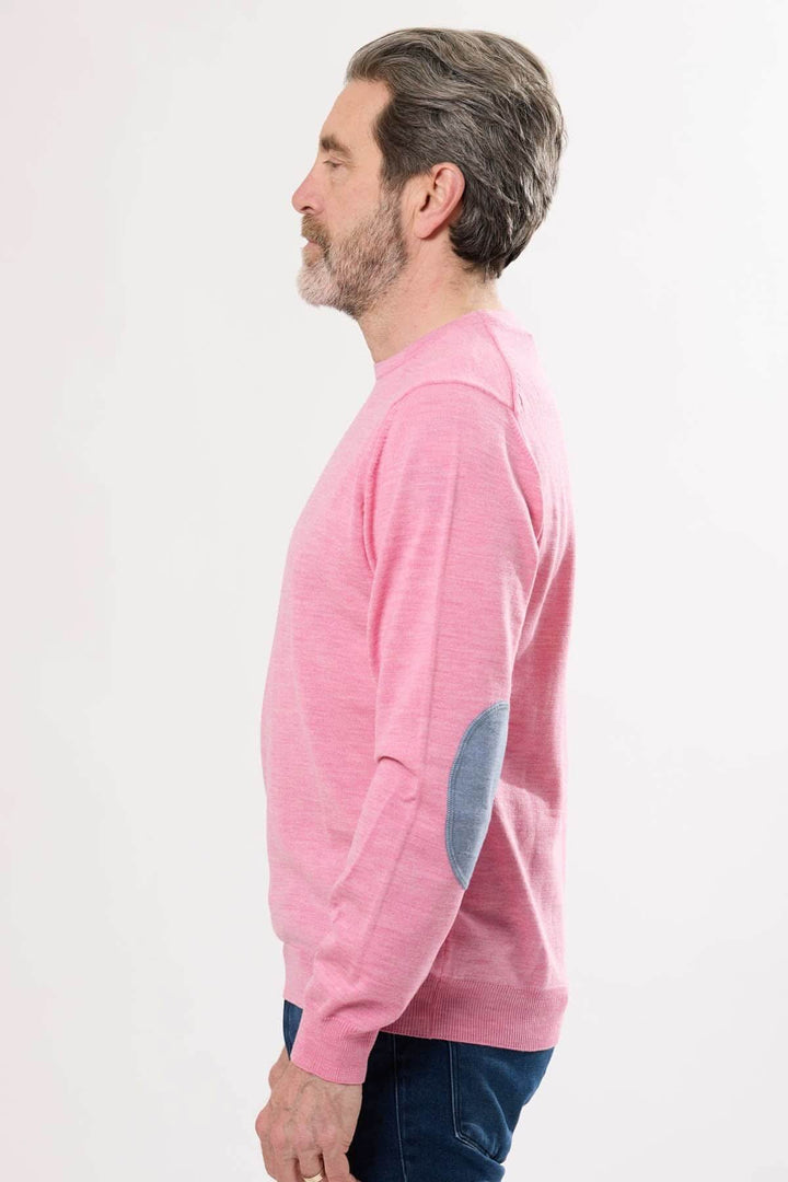 Homme portant un chandail léger rose à col rond avec coudières en tissu contrasté.