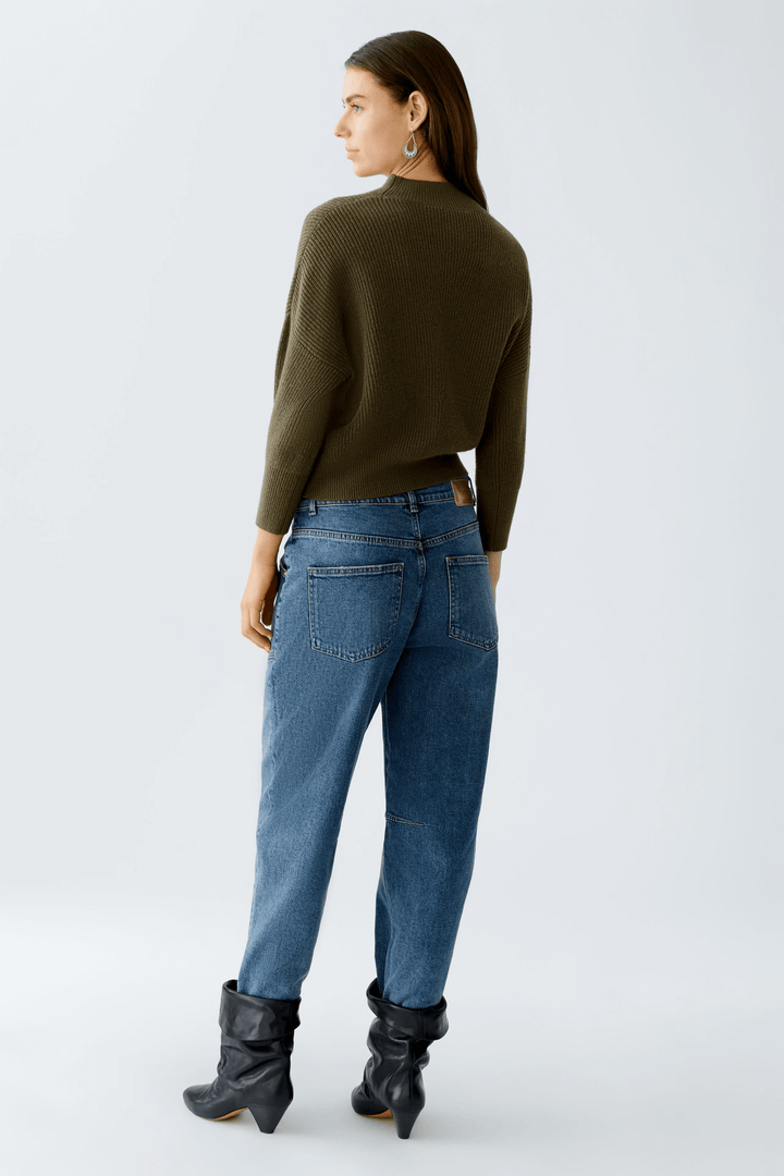 Femme portant un chandail maille fine et un jean, vue arrière.