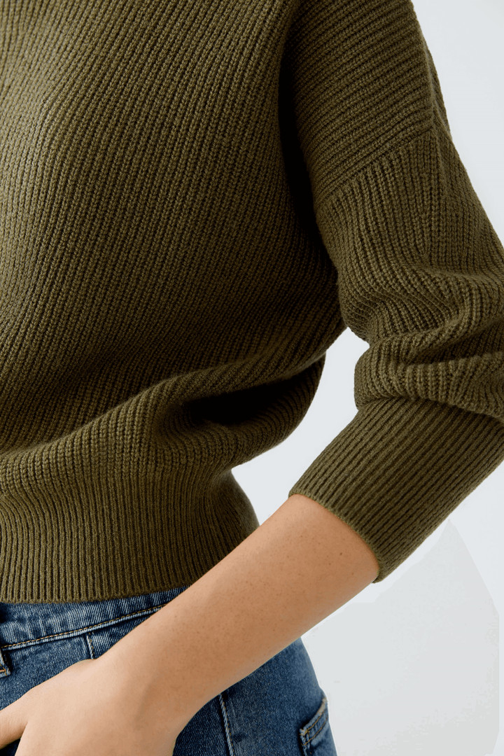 Chandail maille fine vert à col montant avec manches longues et coupe légèrement ample pour un style chic et confortable.