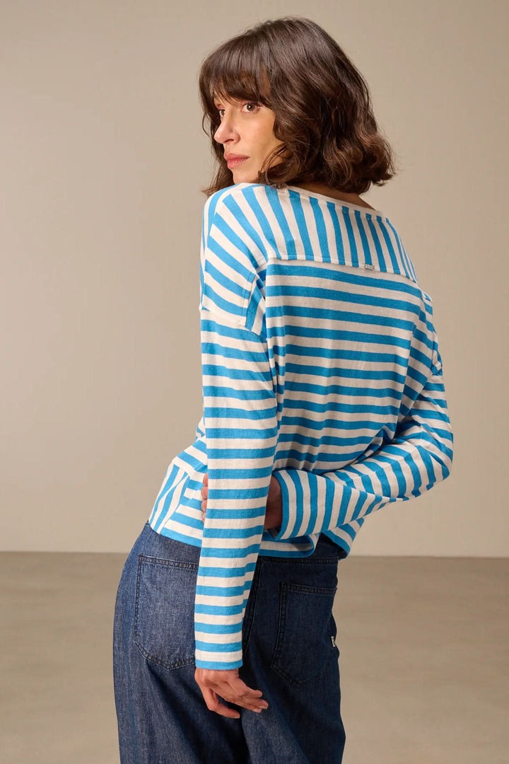 Femme portant un chandail à manches longues rayé coupe décontractée en bleu et blanc, vue arrière.