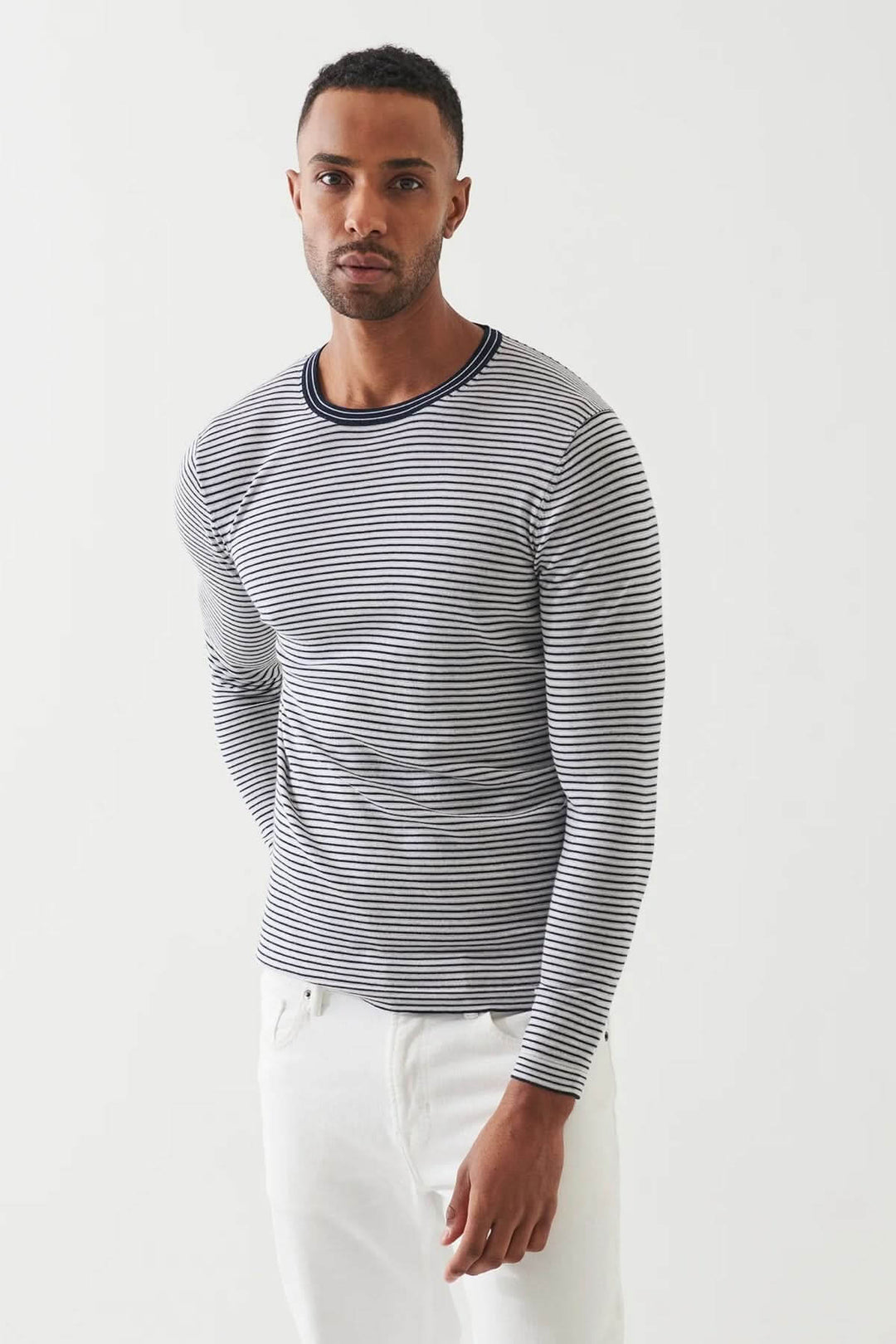 Homme portant un chandail à rayures horizontales avec encolure ronde, parfait pour un look décontracté ou élégant.