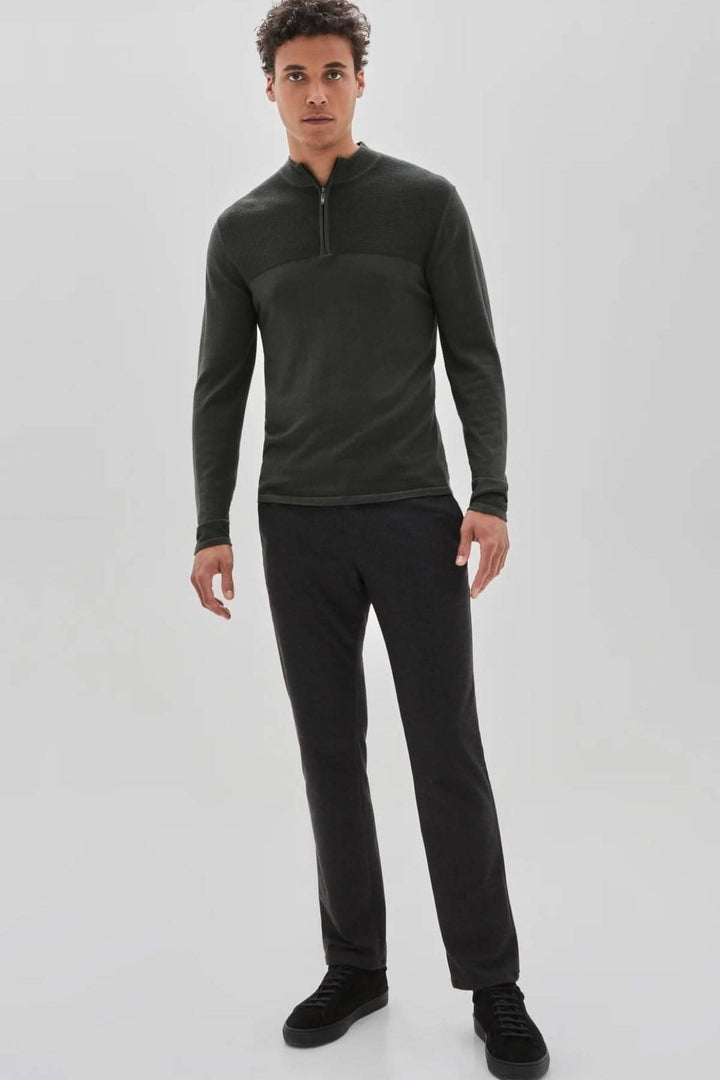Homme portant un chandail zippé Newbury en laine mérinos, avec pantalon sombre et chaussures noires.