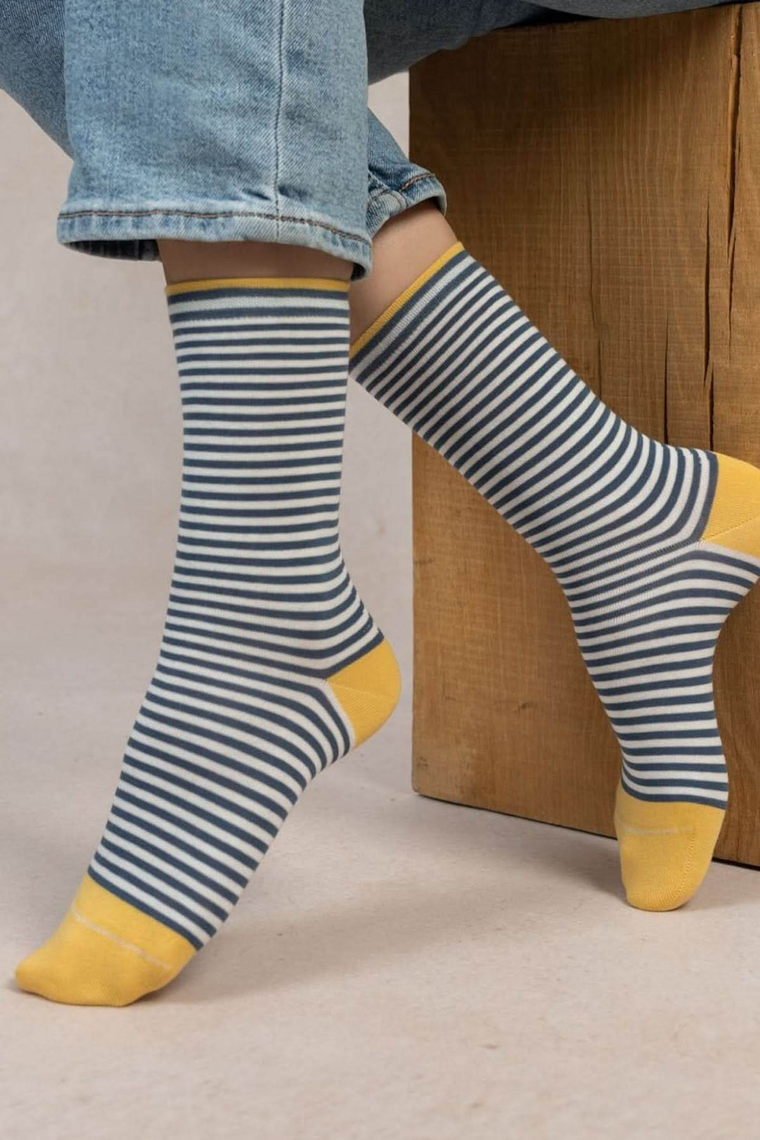 Chaussettes en coton rayées bleu et jaune, confortables et tendance, portées avec un pantalon en jean.