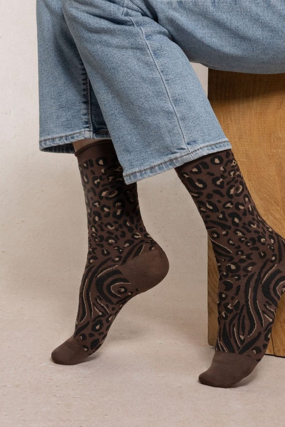 Chaussettes en maille à motif animalier portées avec un jean, élégantes et confortables, idéales pour les journées fraîches.