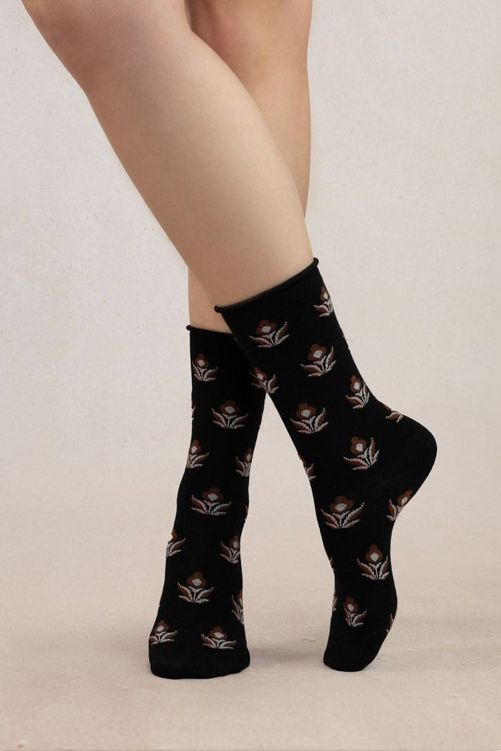 Chaussettes à fleurs noires pour femme, en laine mérinos et coton doux, style féminin et délicat.