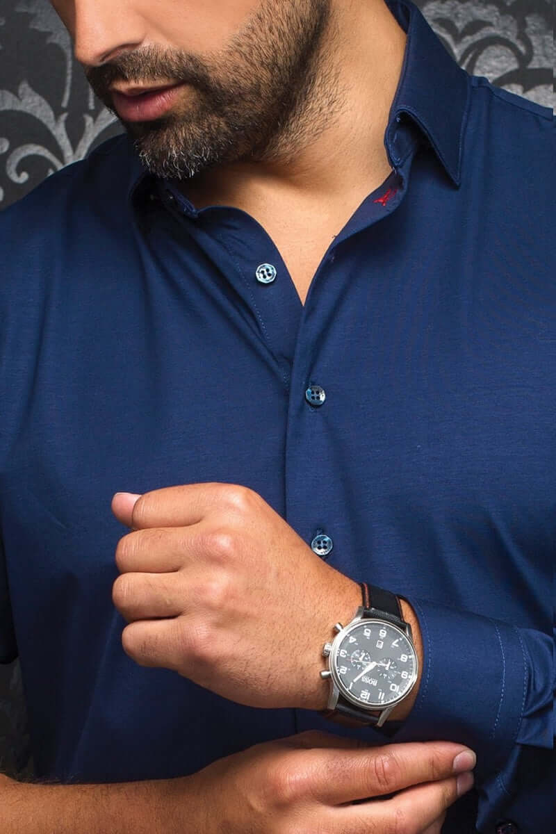 Homme portant une chemise Alexander bleu marine avec boutons noirs, montrant sa montre élégante.