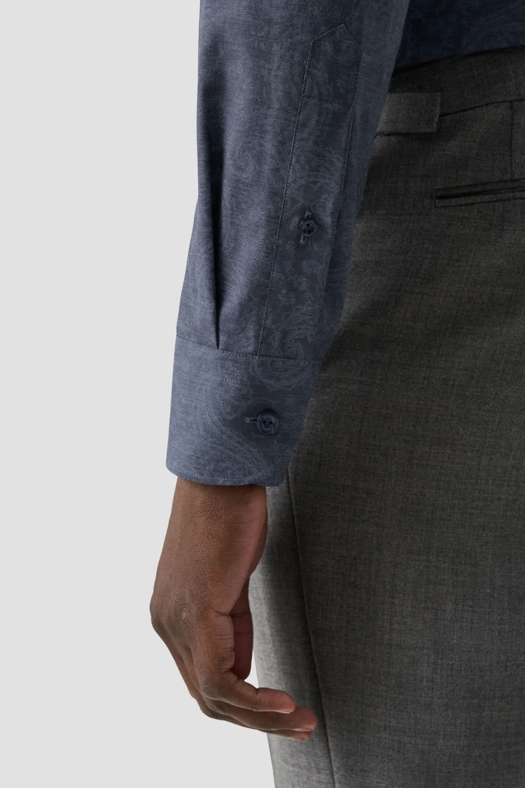 Détail d'une chemise ajustée à imprimé cachemire, avec une coupe moderne et des manches grises.