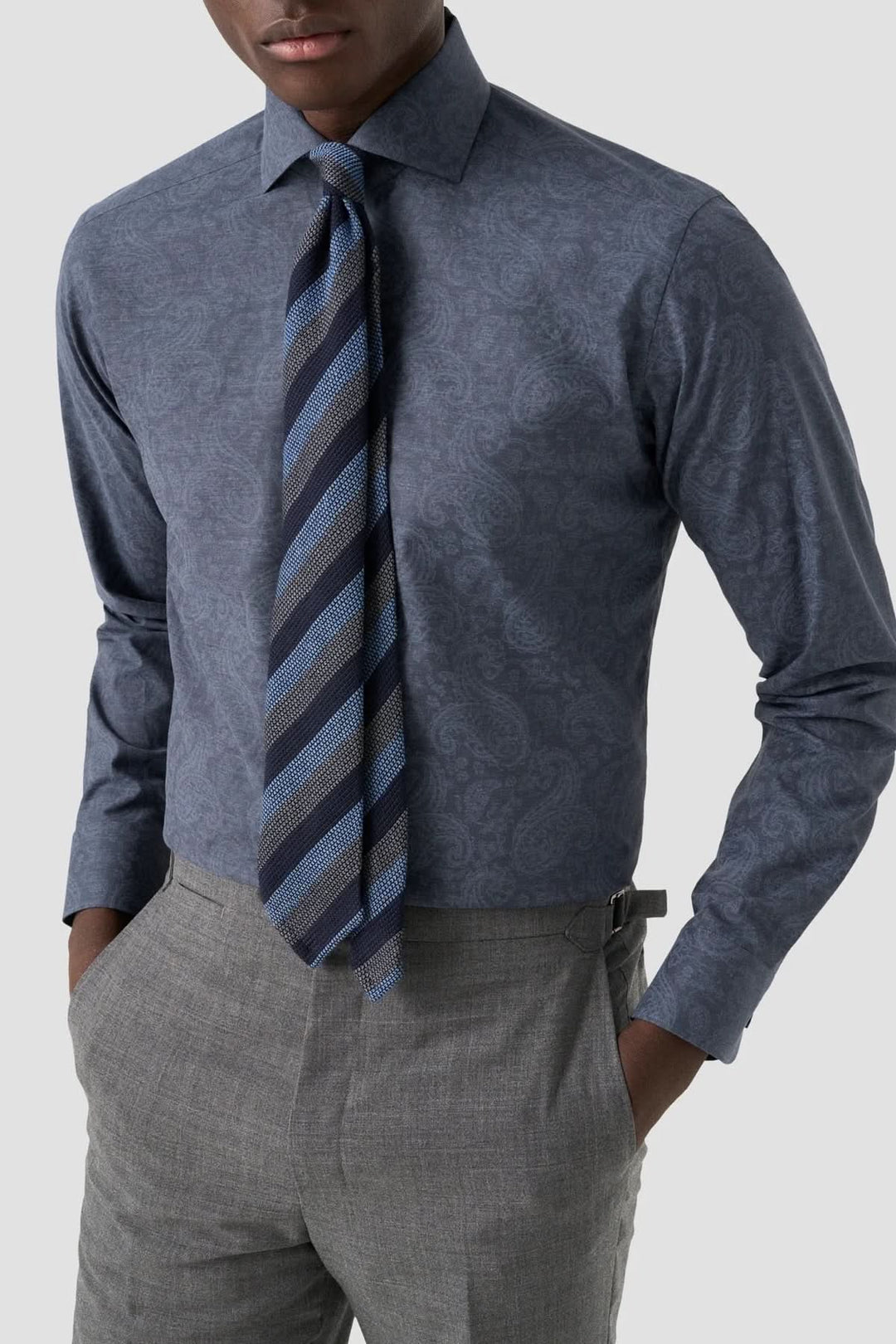 Chemise ajustée à motif paisley bleu avec cravate rayée et pantalon gris pour un style formel élégant.