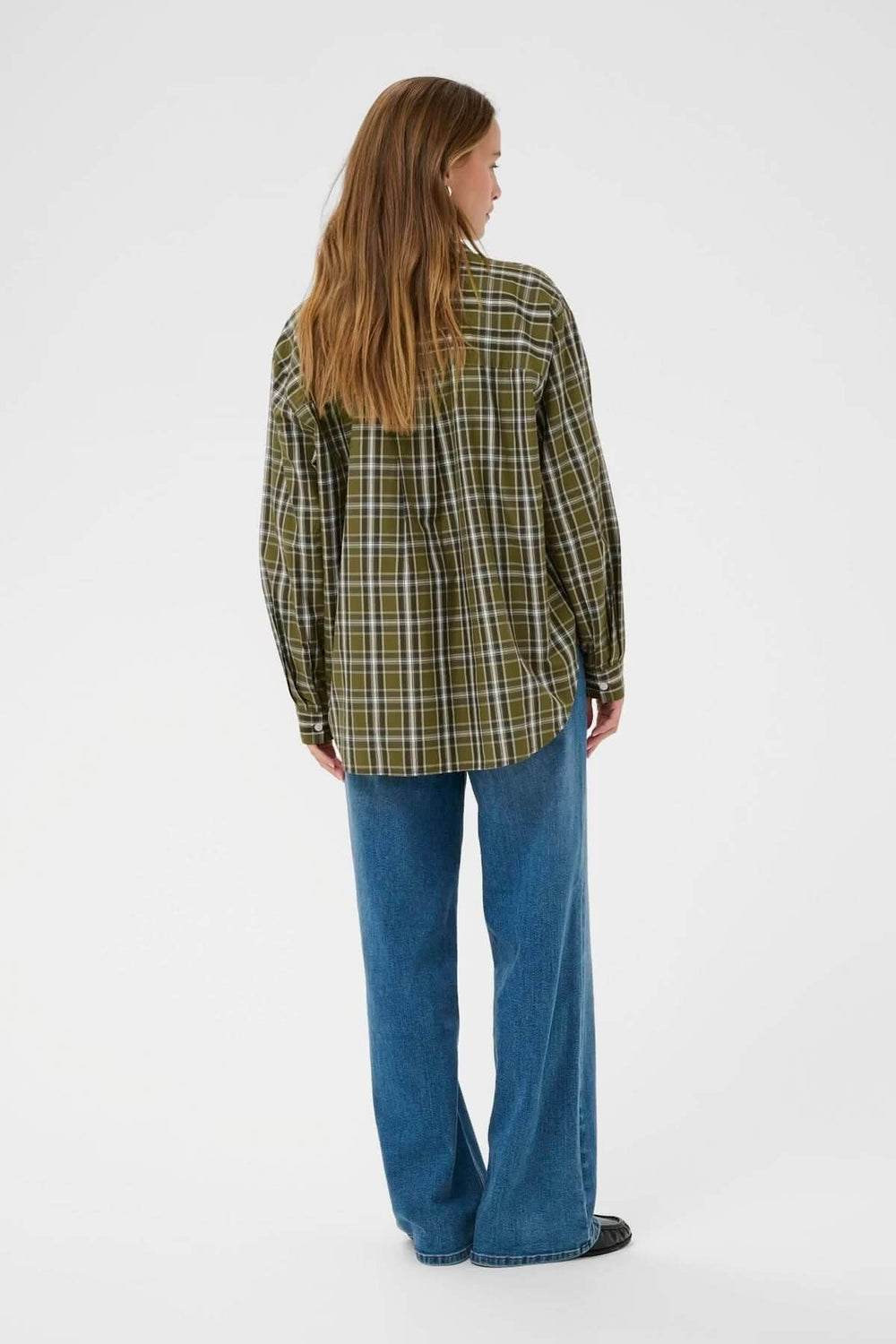 Femme portant une chemise à carreaux vert, modèle décontracté avec jean, vue arrière, style casual chic idéal pour le quotidien.